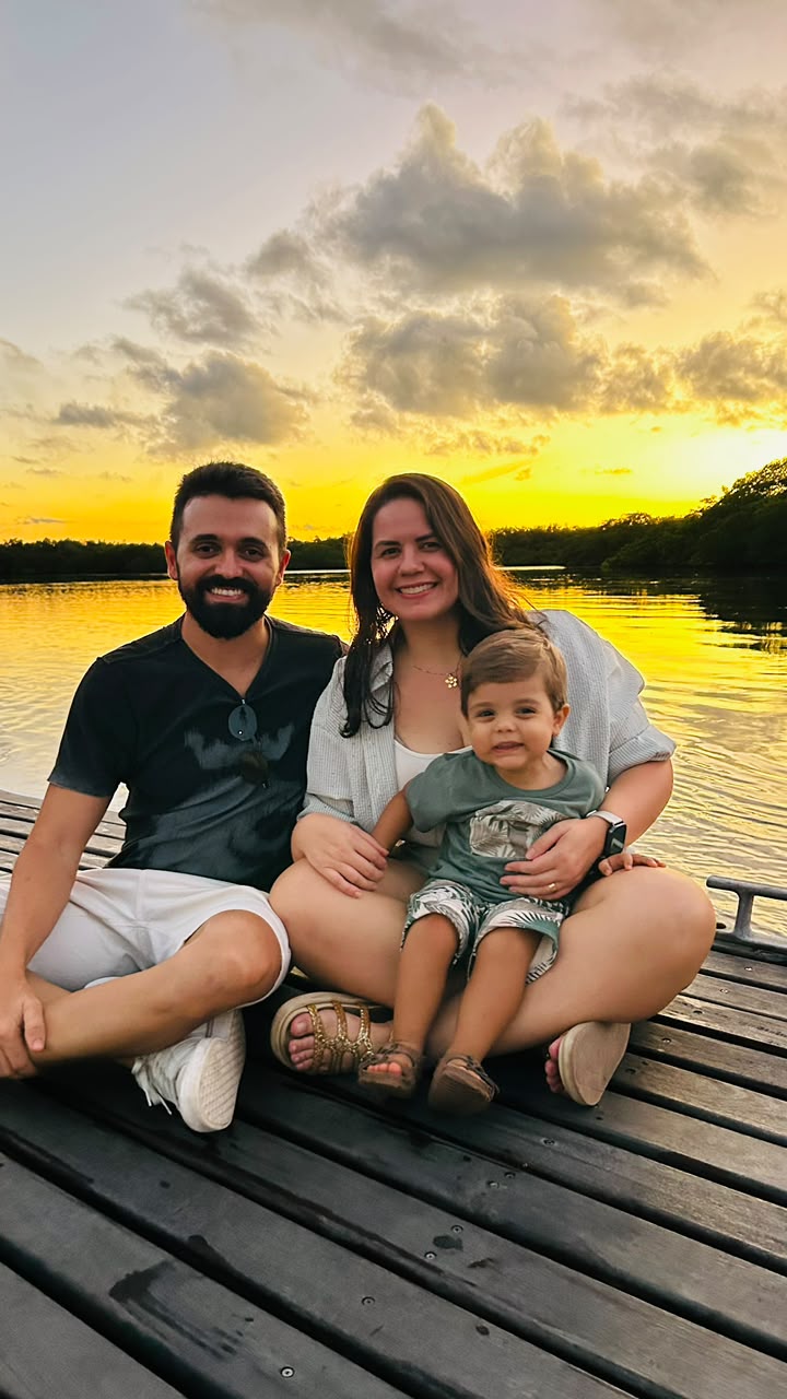 Família no pôr do sol à beira do rio